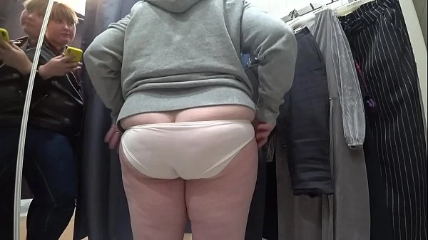 A plump milf with a juicy ass in white panties and big tits in a bra got into the lens of a hidden camera in a public dressing room.